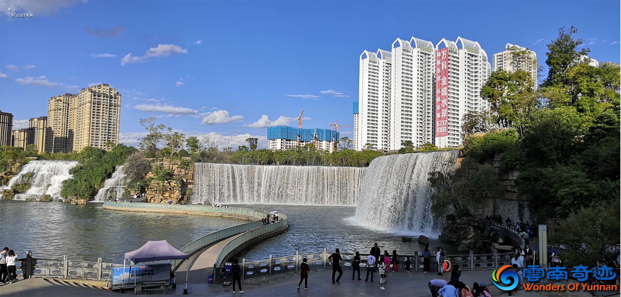 View from the upper platform south of the waterfall over the 400-meter width cascades and the natural waterfalls people watching the water enjoying the sun and walking over the glass bridge in front of the cascades 