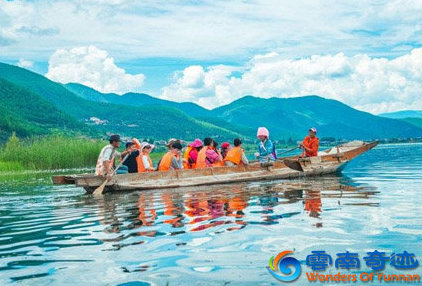 mosuo ethnic minority takes tourists on canoe over lugu lake lijiang yunnan china