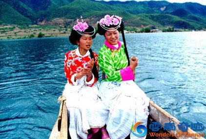 Mosuo ethnic minority girls sitting on a canoe boat on Lugu lake lijiang yunnan china