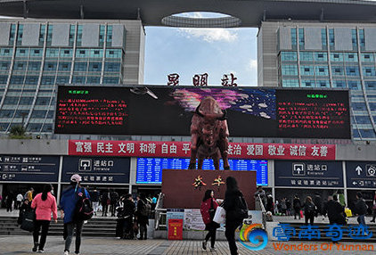 Train station with building and statue and people waiting for their train