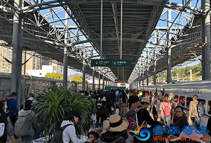 Train station with building and statue and people waiting for their train