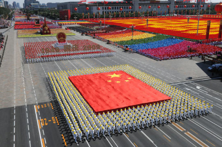 soldiers march at the october national day parade holding a big national chinese flag